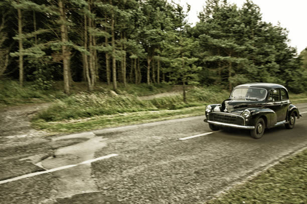 Black Morris Minor Black Morris Mini Minor 1000 saloon. Taken on a road near Druridge Bay, Northumberland. saloon car stock pictures, royalty-free photos & images