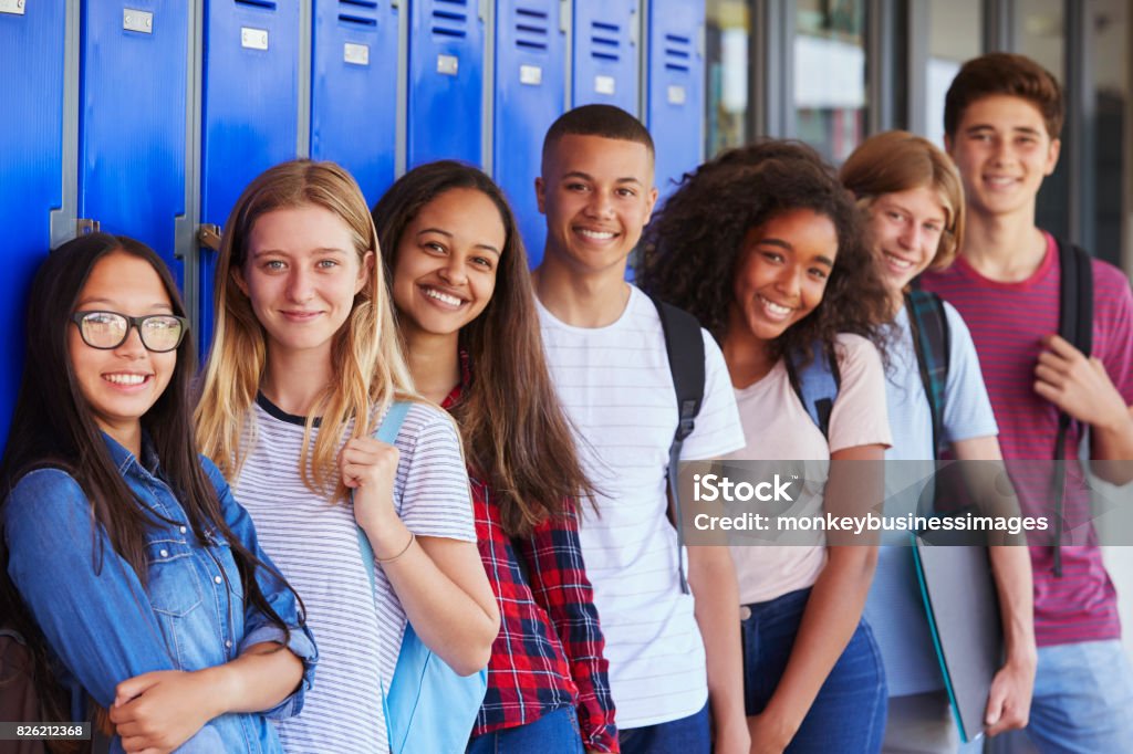 Teenage school kids smiling to camera in school corridor Teenager Stock Photo