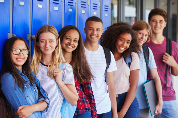 teenage school kids smiling to camera in school corridor - high school imagens e fotografias de stock