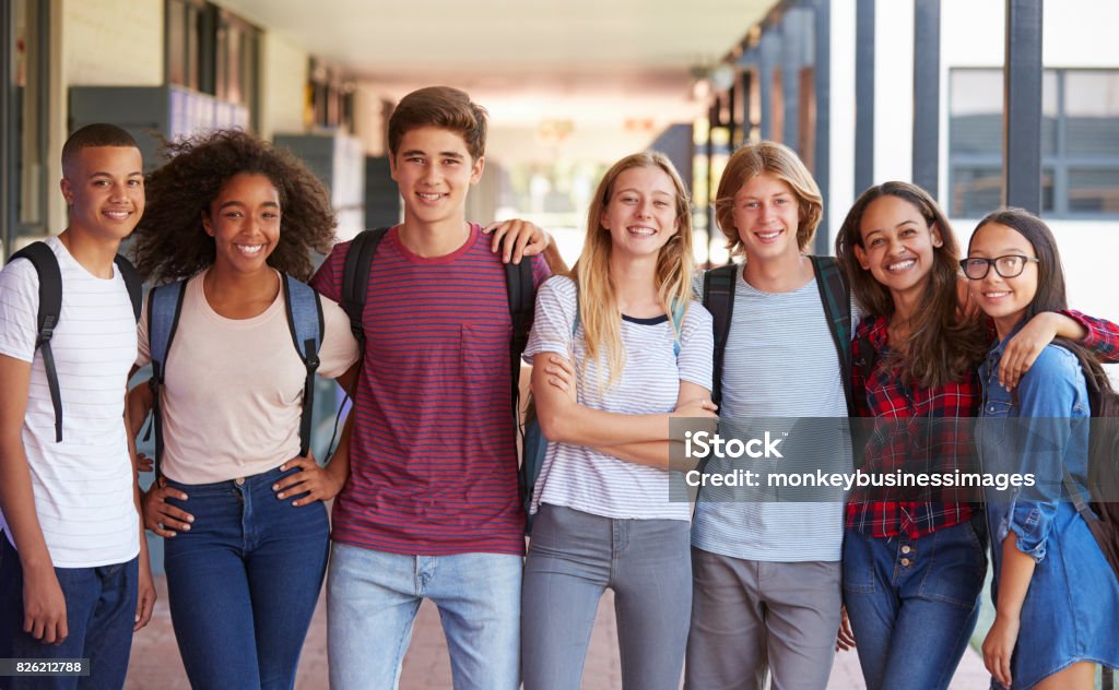 Compagni di classe adolescenti in piedi nel corridoio del liceo - Foto stock royalty-free di Educazione secondaria