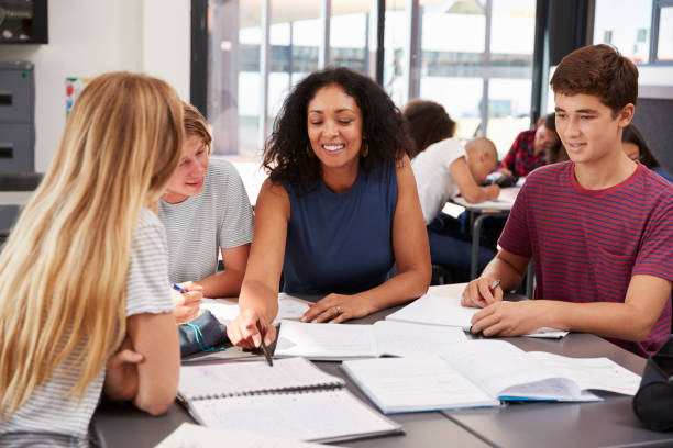 istock Teacher studying school books in class with high school kids 826217142