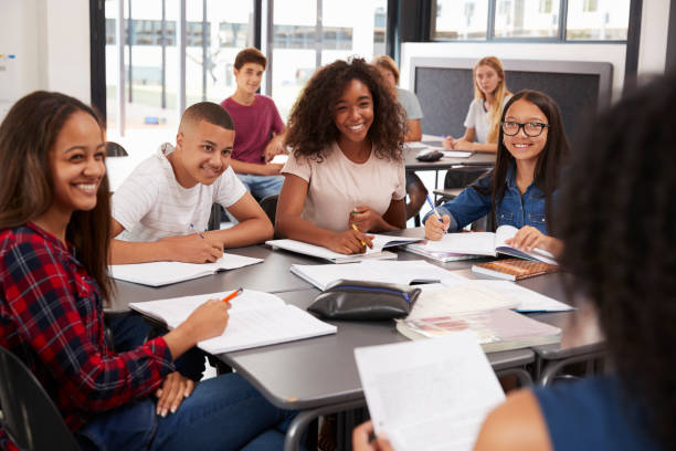 high school kids looking to teacher sitting at their desk - multi ethnic group concentration student asian ethnicity imagens e fotografias de stock