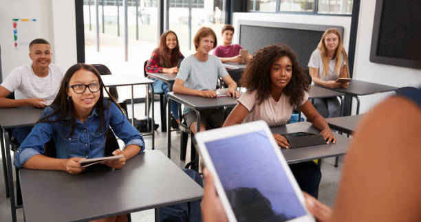 istock Teacher uses tablet in high school class, over shoulder view 826220252