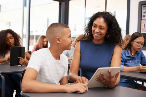istock Teacher helping teenage schoolboy with tablet computer 826220608