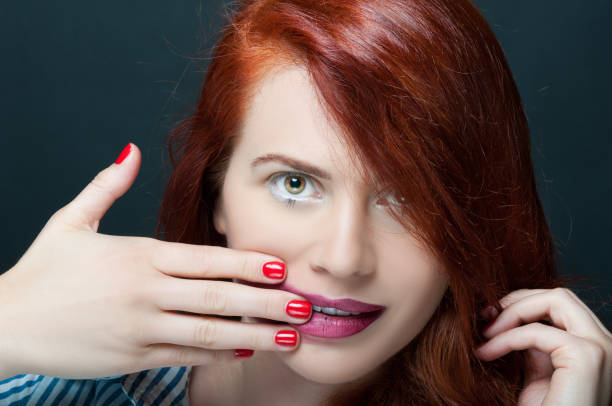 istock Beautiful young woman with makeup smearing lipstick 826224358