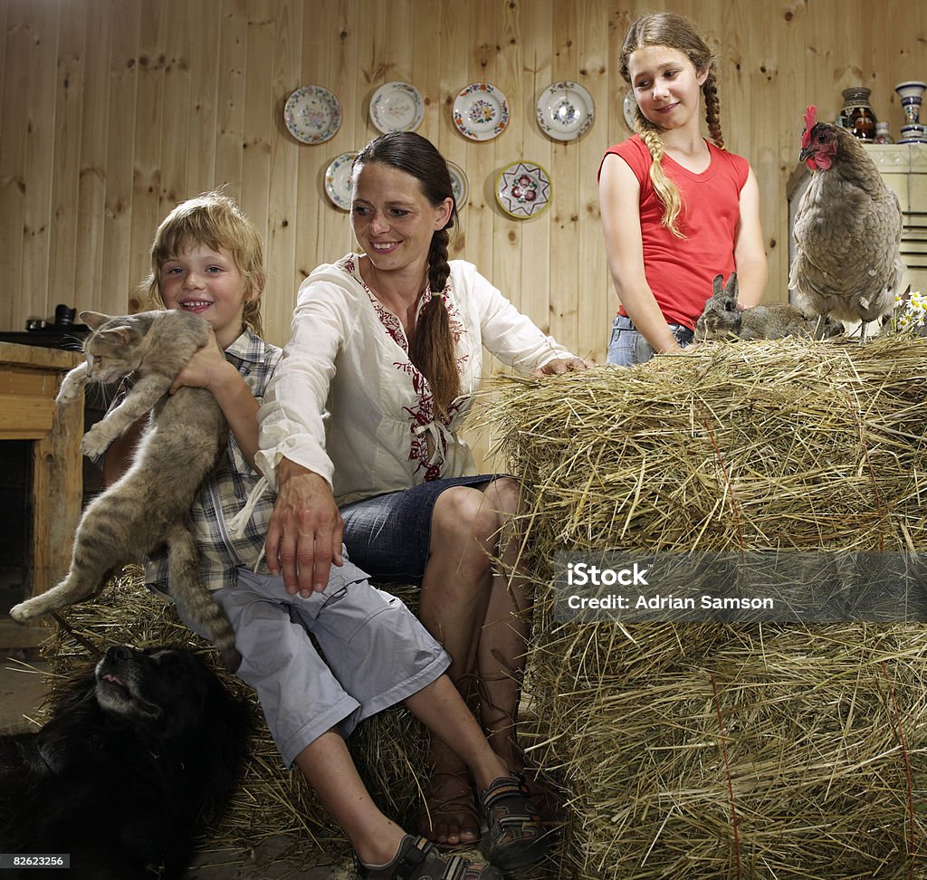 Mother and children in farm kitchen with animals  10-11 Years Stock Photo