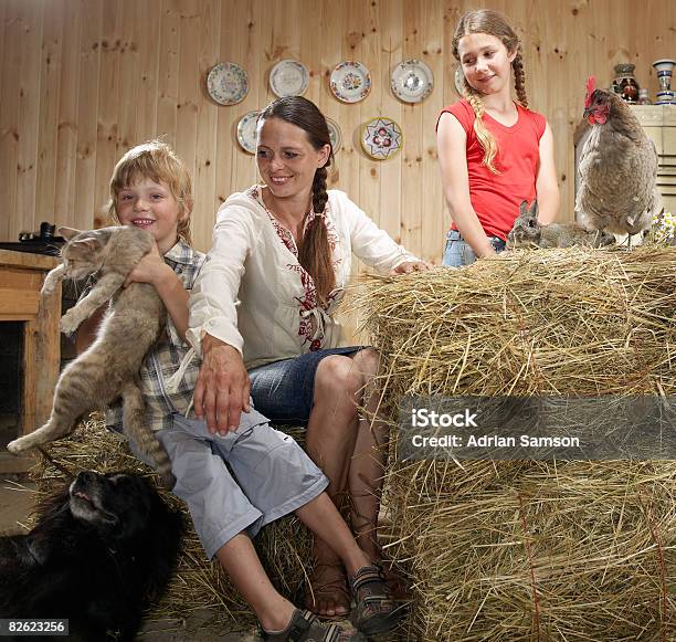 Mother And Children In Farm Kitchen With Animals Stock Photo - Download Image Now - 10-11 Years, 35-39 Years, 4-5 Years