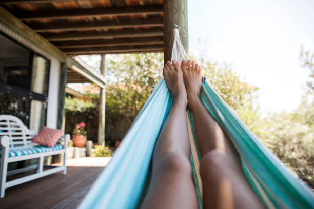 Feet on a Hammock Point of view shot of a young woman's feet as she is lying down on a hammock. hammock relaxation women front or back yard stock pictures, royalty-free photos & images