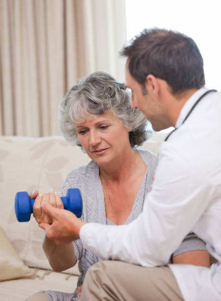 istock Handsome doctor helping his patient to do exercises 826251420