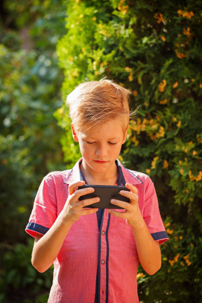 istock Little boy child kid playing games on smartphone mobile phone ou 826252202