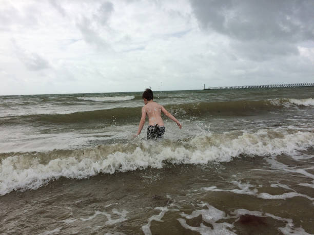 istock 8 year swimming in the rough sea 826255040