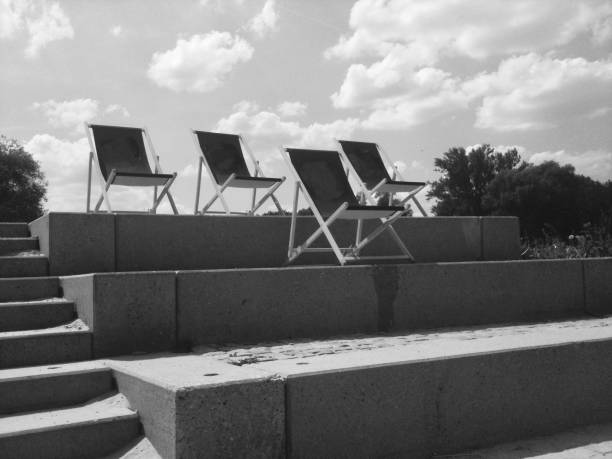 istock Four black vintage deck chairs standing in a row 826255544