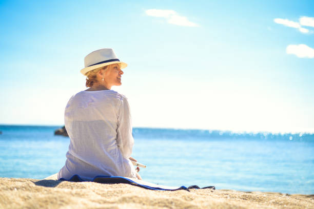 istock Female on the beach with white hat. 826269118