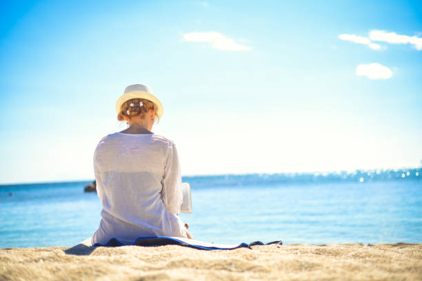 istock Female on the beach with white hat. 826269166
