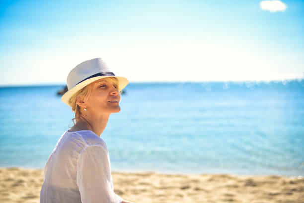istock Female on the beach with white hat. 826269402