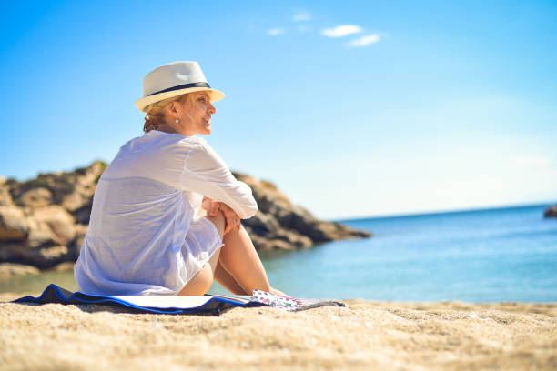 istock Female on the beach with white hat. 826272610