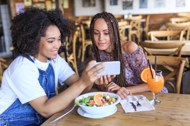 istock Cheerful friends using smart phone in cafeteria 826273086