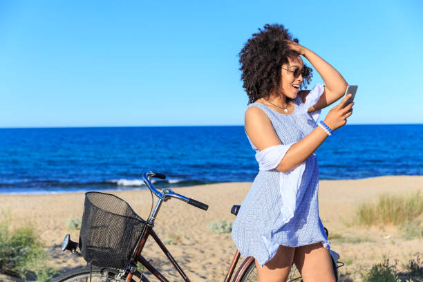 istock Woman with smart phone riding on sand 826273146