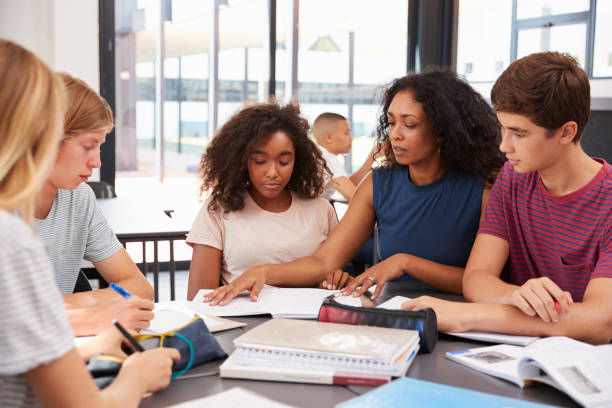istock Teacher studying school books in class with high school kids 826276886