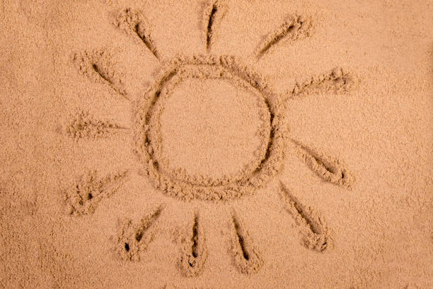 istock Sun drawn in soft wet sand on a beach 826280962