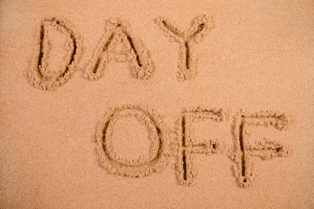 istock Day Off written in soft wet sand on a beach 826284908