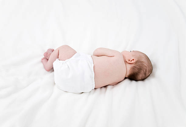 baby girl (0-3 months) laying on bed, rear view - 3109 - fotografias e filmes do acervo