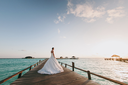 The beautiful bride on a pier near water bungalows
