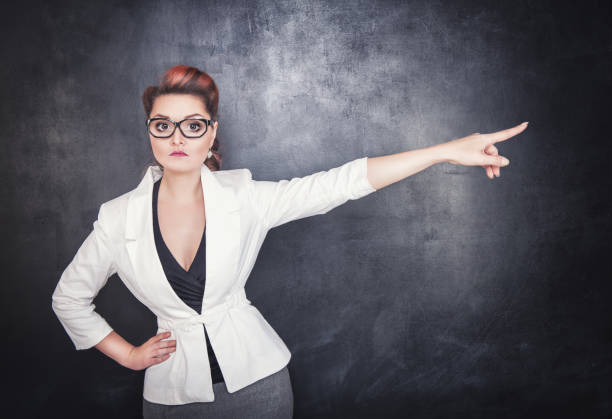 istock Serious woman teacher pointing out 826293354