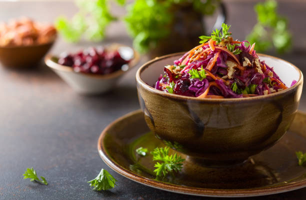 salad Red cabbage, carrot, apple salad with nuts and cranberry. Coleslaw for autumn or winter season. coleslaw stock pictures, royalty-free photos & images