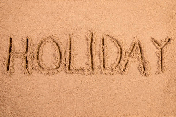 istock Holiday written in soft wet sand on a beach 826296806