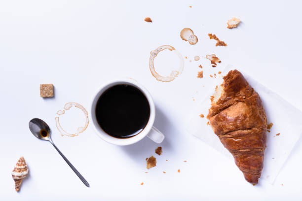 istock Black coffee with fresh croissant for breakfast on white table. 826297054