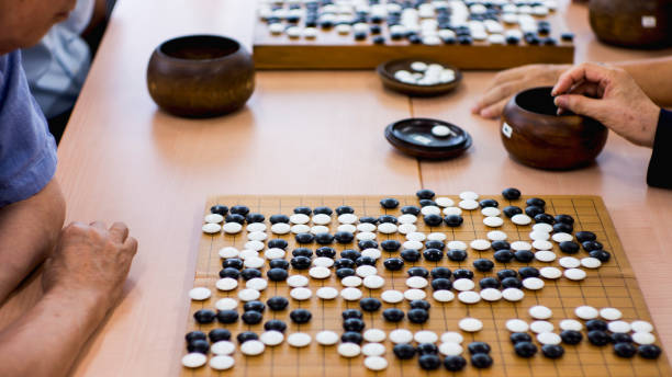 istock Side view of people playing Go bord game 826301228