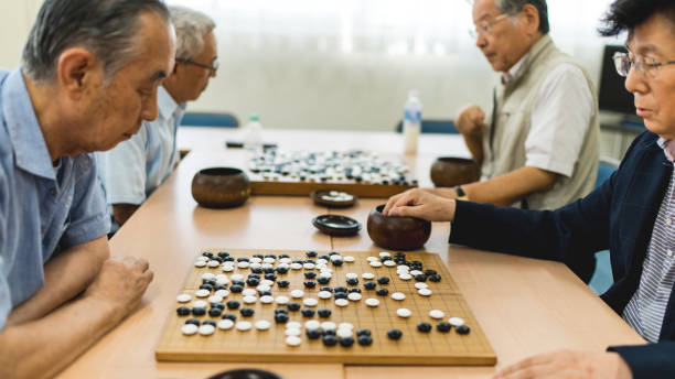 istock Side view of senior men playing Go asian bord game 826301280
