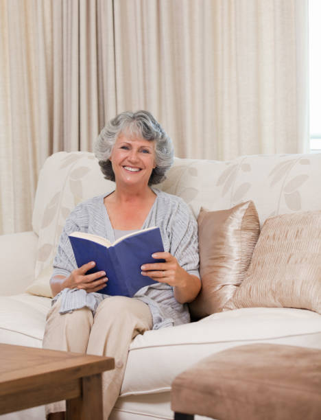 istock Senior woman reading a book 826305184