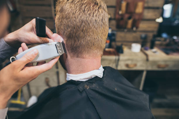 istock barber cutting hair of customer 826311908