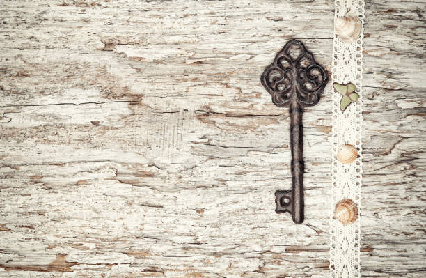 istock Vintage background with old key and lacy cloth on wood 826316668