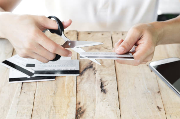 istock woman is cutting credit card with scissors 826319704