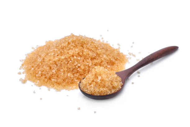 istock brown cane sugar in wooden spoon isolated on white background 826327282
