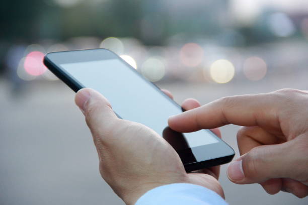 istock Male hand using smart phone on city street 826331042