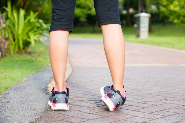 Sporty woman ankle sprain while jogging or running at park. stock photo