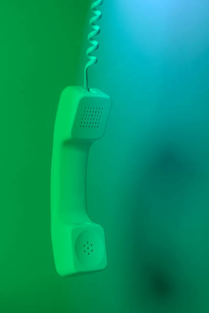 телефонный приемник и шнур на зеленом фоне. - telephone telephone receiver phone cord telephone line стоковые фото и изображения