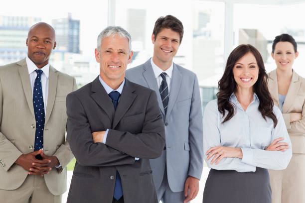 istock Smiling business team standing in front of a bright window 826345418