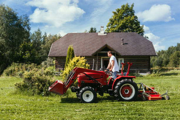 Farmer mowing with Tractor Northern Europe, real young farmer. garden tractor stock pictures, royalty-free photos & images