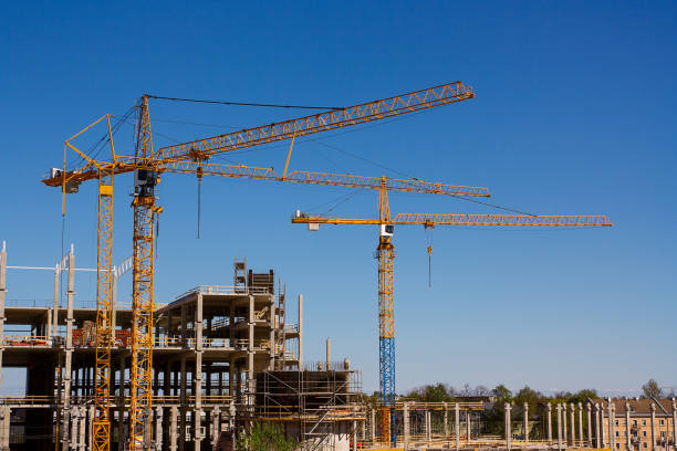 istock Construction tower cranes and high-rise building under construction against blue sky 826350848