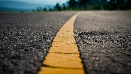 Asphalt highway with yellow line detail on road background