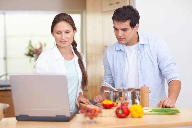istock Couple using a laptop to cook 826358610