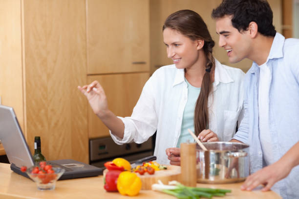 istock Smiling couple using a laptop to cook 826359000