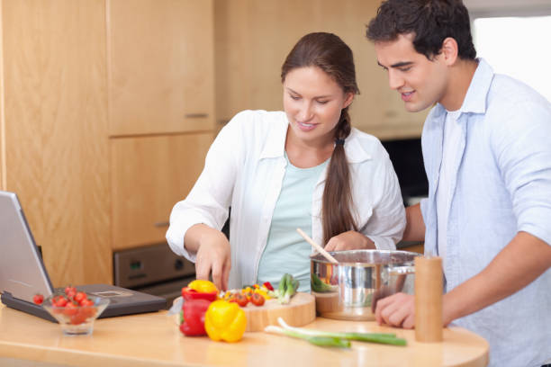 istock Happy couple using a laptop to cook 826359080
