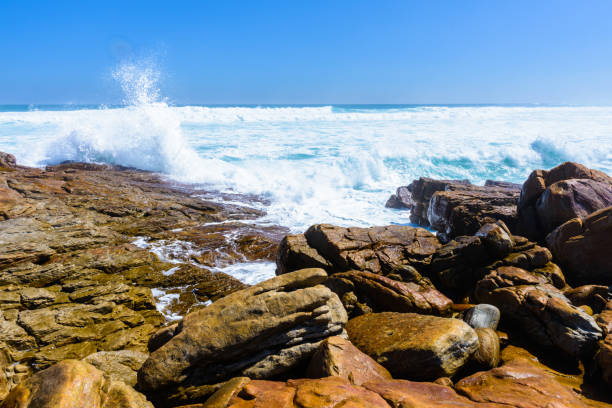 istock Ocean water hits against the stones 826361780