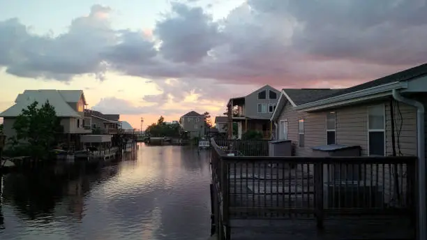 Sun setting in Slidell, Louisiana with houses on a river.